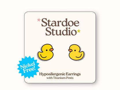 Small yellow duck glossy stud earrings jewelry with bright orange bills and adorable round bodies, representing classic pond birds and rubber duckie bath time memories that waterfowl enthusiasts and childhood nostalgia lovers treasure, showcasing farm life and lake culture traditions, secured with hypoallergenic titanium posts, perfect for girls and boys who love swimming birds and aquatic animal accessories