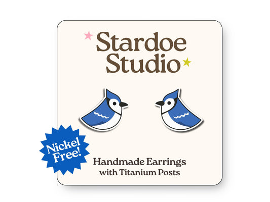 Small blue bird earrings featuring vibrant blue and white coloring with black markings, showcasing the iconic Toronto Blue Jays baseball team colors and beautiful North American songbird details, representing both sports fandom and birdwatching culture, secured with hypoallergenic titanium posts, perfect for kids who love baseball teams and backyard bird watching