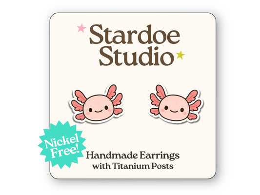 Little axolotl stud earrings featuring a cute pink amphibian design with gills and a smiling face. These earrings are handmade with hypoallergenic titanium posts animal jewelry for kids and adults.