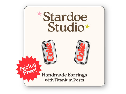 A pair of diet coke studs featuring the iconic diet coke can design. These earrings are handmade with hypoallergenic titanium posts novelty jewelry for kids and adults.