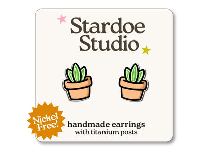 Little plant pot stud earrings featuring a small green plant in a orange pot. These earrings are handmade with hypoallergenic titanium posts botanical jewelry for kids and adults.