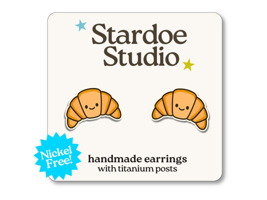 Little croissant stud earrings featuring a golden pastry design. These earrings are handmade with hypoallergenic titanium posts food jewelry for kids and adults.