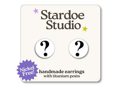 Little white question mark stud earrings featuring a bold and playful question mark design. These earrings are hypoallergenic titanium posts fun symbol jewelry for kids and adults.