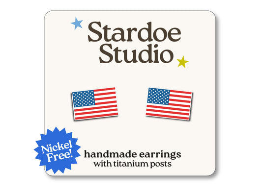 Little American flag stud earrings featuring the red white and blue design of the national flag. These earrings are hypoallergenic titanium posts patriotic jewelry for kids and adults.